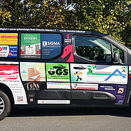 Seitenansicht des mit Werbeanzeigen beklebten Fahrzeugs des Chemnitzer Kabaretts