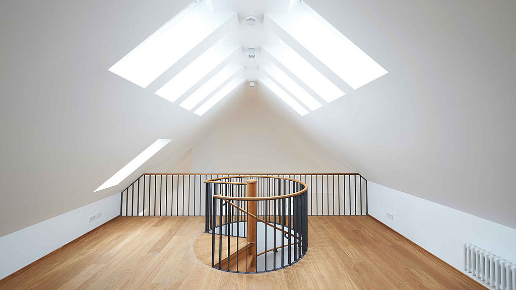 Blick in einen ausgebauten Dachboden mit Treppenaufgang